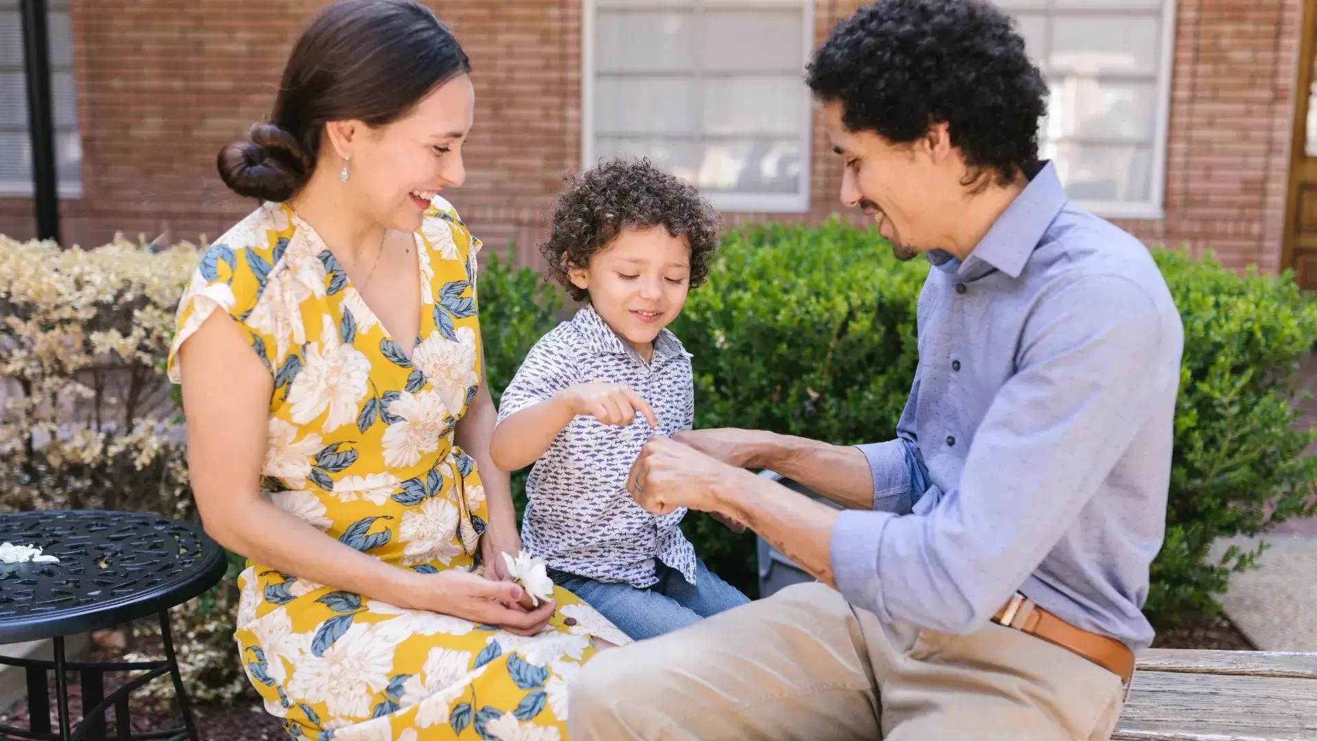 Co-parents playing joyfully with their child, illustrating a supportive parenting partnership nurtured through co-parenting counselling at Mississauga Divorce Counselling Therapy.