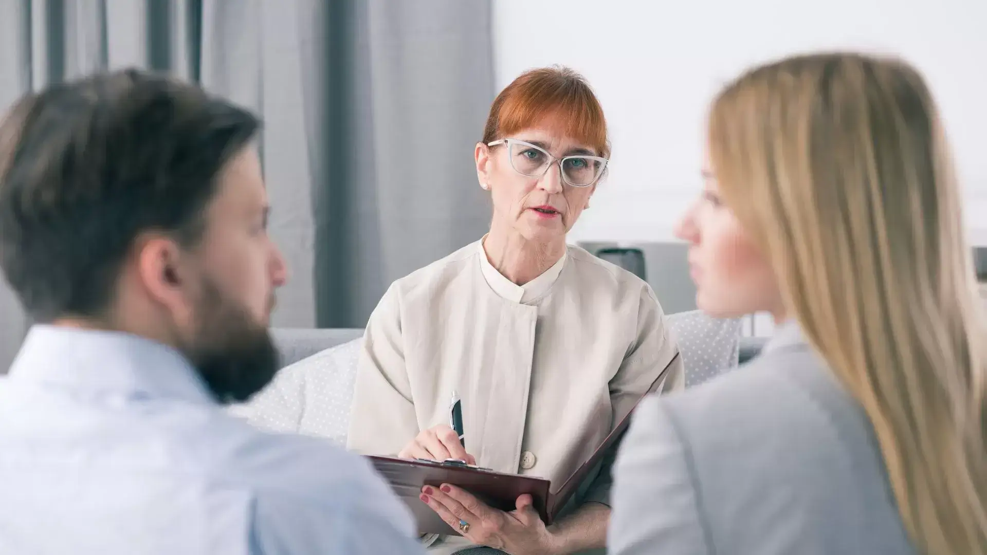 Two couples engaged in conversation while a divorce therapist observes and takes notes during a Grief and Closure Therapy session at Mississauga Divorce Counselling Therapy, facilitating emotional closure and peace after divorce.