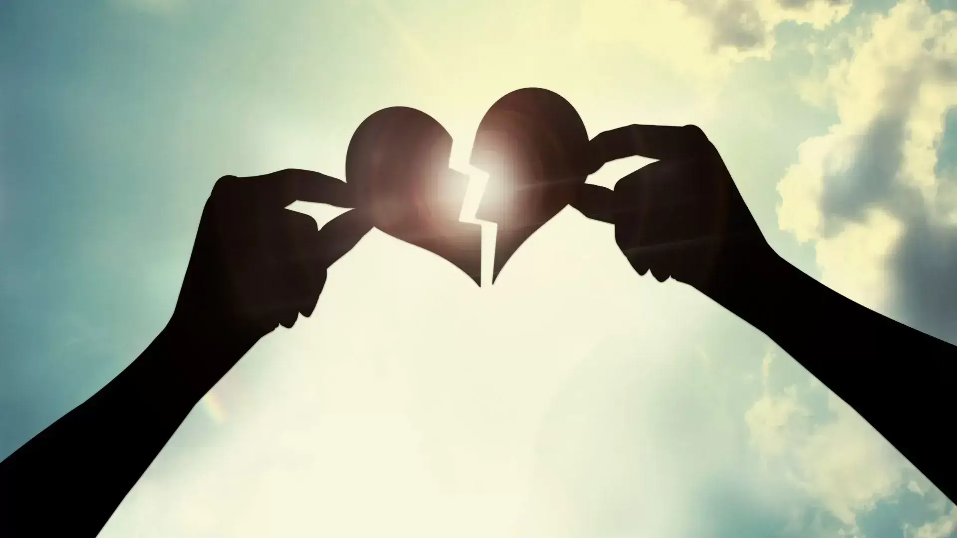 Couple holding two halves of a heart and bringing them together during a session at Mississauga Divorce Counselling Therapy, symbolizing emotional healing and self-reconnection after a relationship ends.