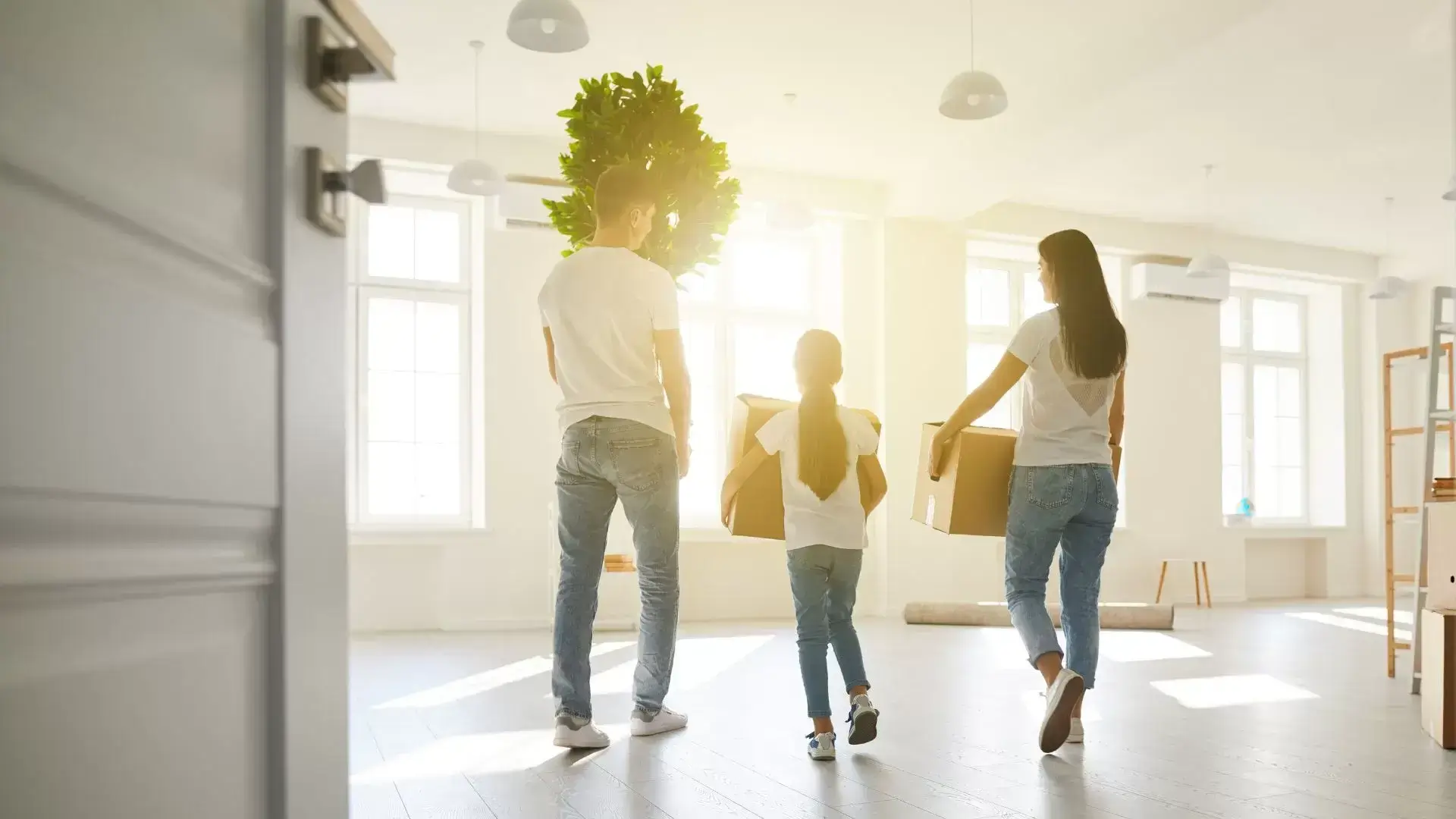 Co-parents with their child carrying a box together, symbolizing empowered forward movement and new beginnings after divorce, supported by Mississauga Divorce Counselling Therapy.