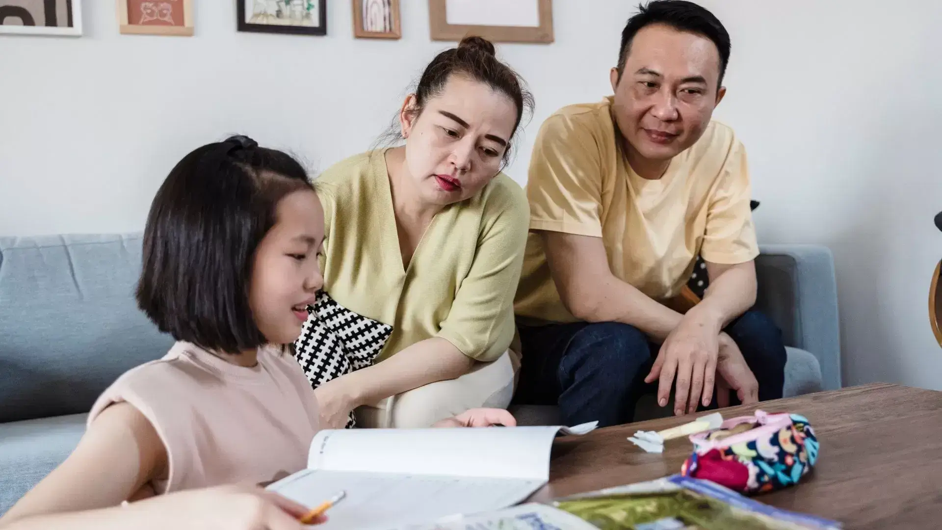 Co-parents working together with their child on writing or studying, symbolizing shared responsibilities and structured parenting supported by Mississauga Divorce Counselling Therapy.