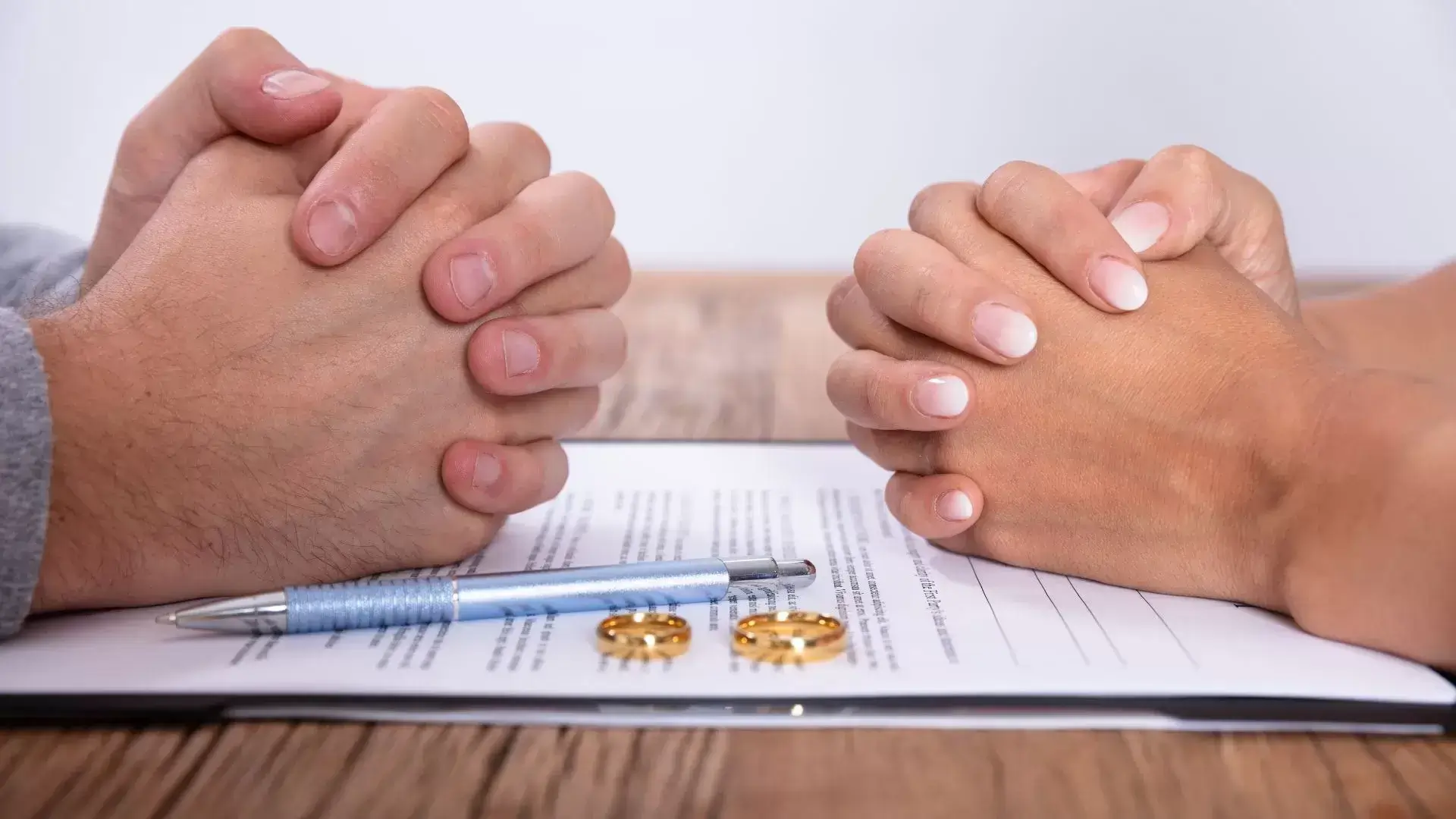 Couple holding their own hands beside wedding rings, paper, and pen during a Divorce Recovery Coaching session at Mississauga Divorce Counselling Therapy, symbolizing goal-setting and rebuilding life after divorce.