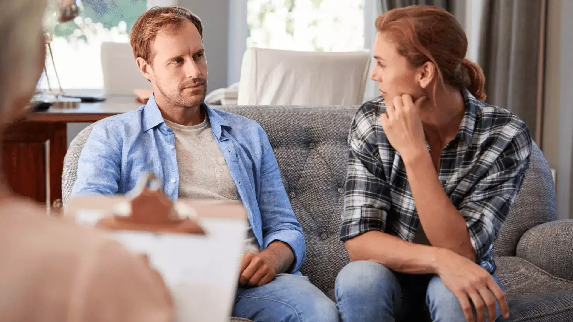 Couple looking at each other during an Internal Family Systems session at Oakville Divorce Counselling Therapy, with the divorce therapist present—demonstrating how IFS supports emotional healing, self-awareness, and reconnection during divorce recovery.